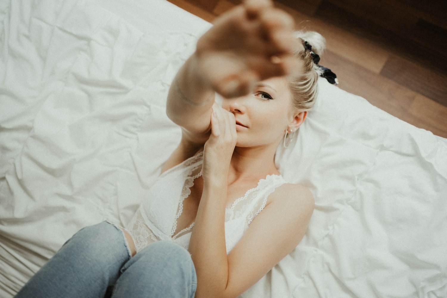 Sustainable LEED woman in white tank top lying on bed