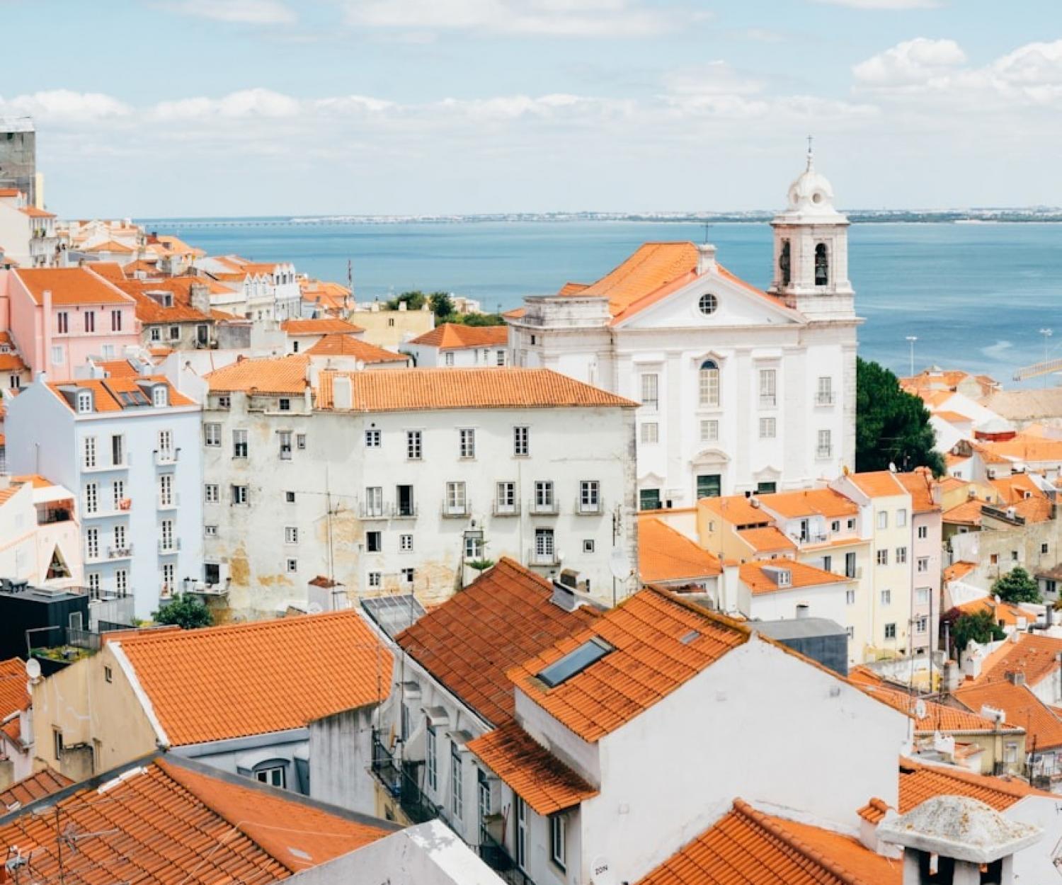 Healthy Buildings Lisbon - landscape photography of orange roof houses near body of water