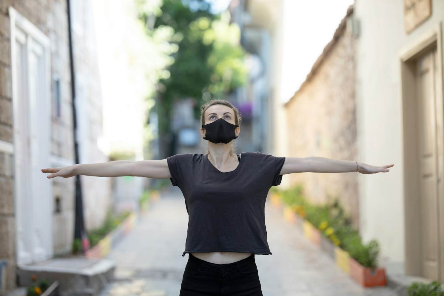 WELL woman in black t-shirt and black shorts raising her hands