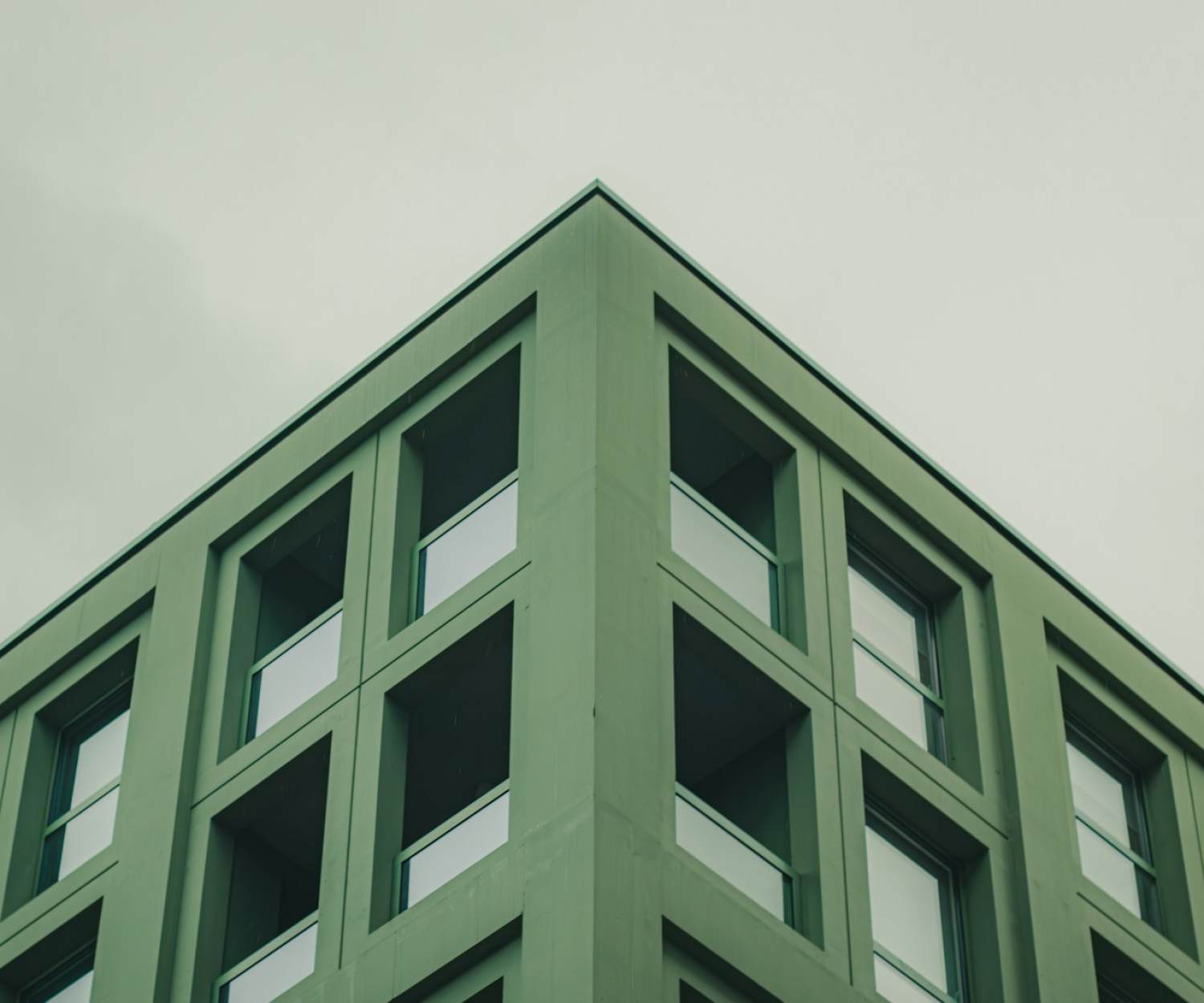 ustainable Consulting Portugal a green building with windows and a sky background
